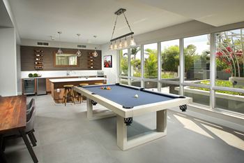 Resident lounge with billiards table, shuffleboard, card room, demonstration kitchen, and more